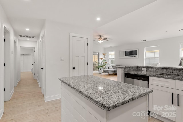 kitchen featuring a sink, a ceiling fan, visible vents, stainless steel dishwasher, and a center island