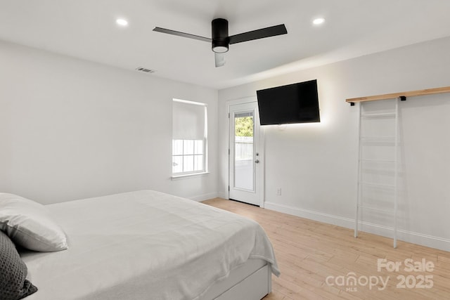 bedroom featuring recessed lighting, visible vents, a barn door, wood finished floors, and baseboards