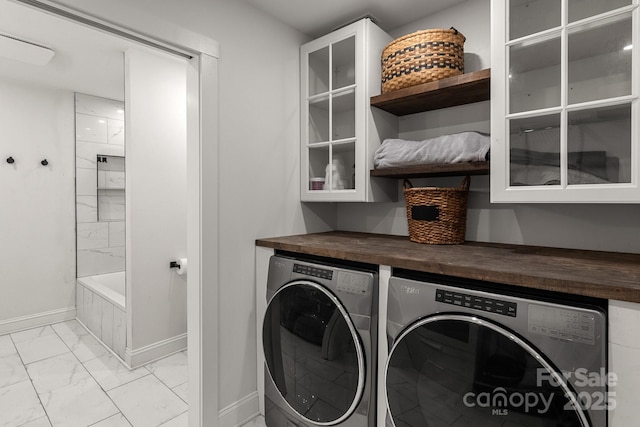 laundry area with marble finish floor, baseboards, separate washer and dryer, and laundry area