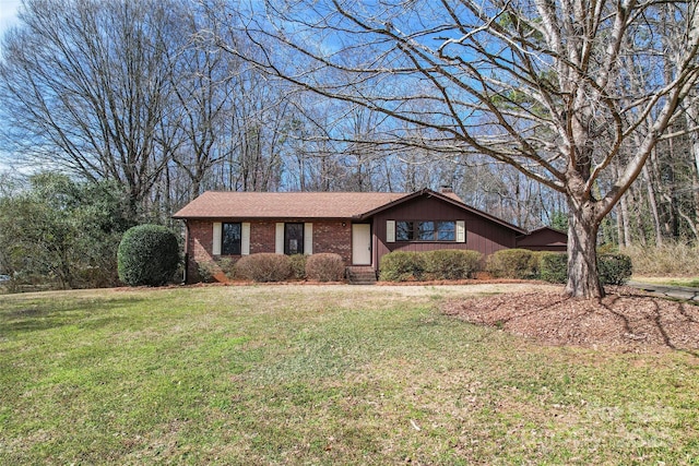 single story home with a front lawn, a chimney, and brick siding