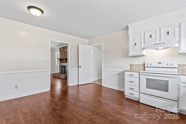 kitchen with dark wood-style floors, white electric range oven, white cabinetry, wainscoting, and under cabinet range hood