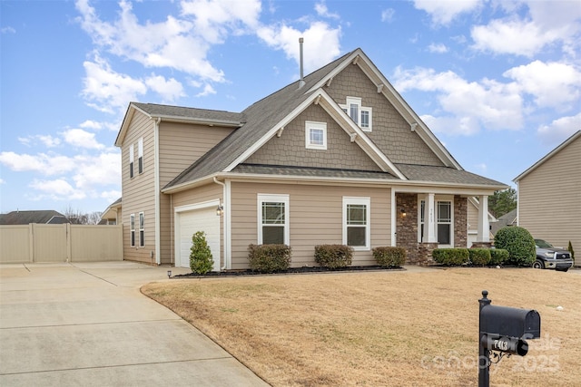 craftsman house with fence, concrete driveway, and a front yard