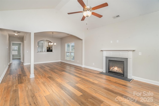 unfurnished living room featuring light wood-type flooring, visible vents, and a glass covered fireplace