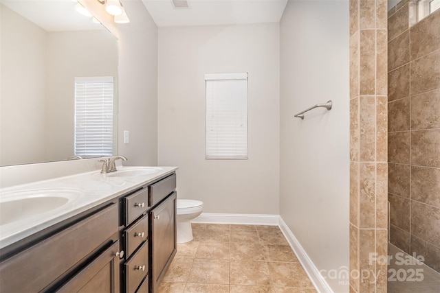 full bath featuring double vanity, visible vents, toilet, a sink, and baseboards