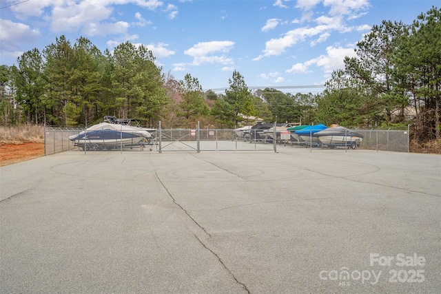 view of vehicle parking with fence and a gate