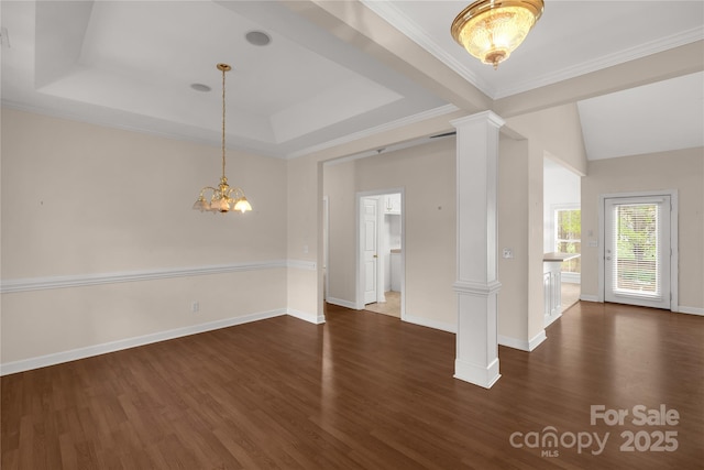 interior space with decorative columns, an inviting chandelier, a raised ceiling, and dark wood-style floors