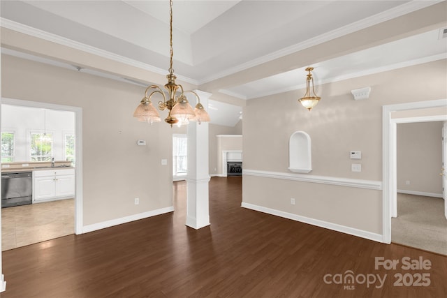 unfurnished dining area featuring wood finished floors, an inviting chandelier, a sink, and plenty of natural light