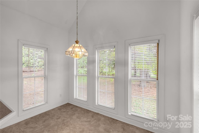 unfurnished dining area featuring a healthy amount of sunlight and high vaulted ceiling