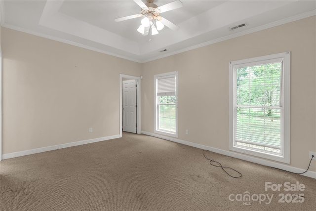 carpeted empty room featuring ornamental molding, visible vents, and plenty of natural light