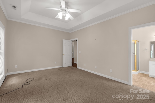 empty room with visible vents, a ceiling fan, a tray ceiling, and a healthy amount of sunlight