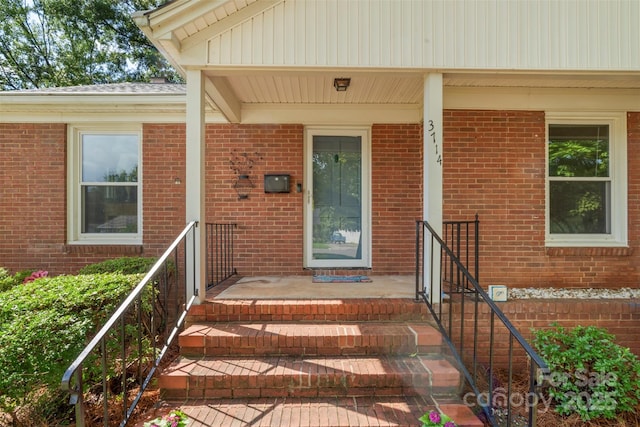 view of exterior entry with brick siding