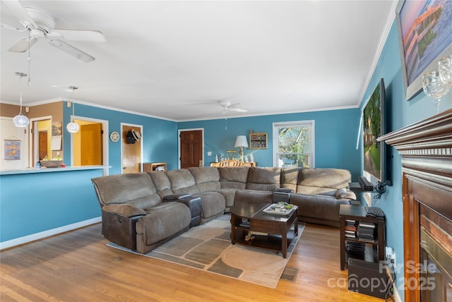 living room with a fireplace, crown molding, visible vents, a ceiling fan, and wood finished floors