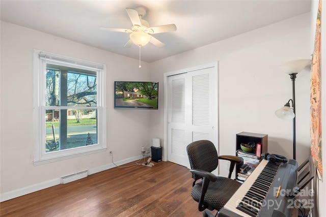 office area with a baseboard radiator, ceiling fan, baseboards, and wood finished floors