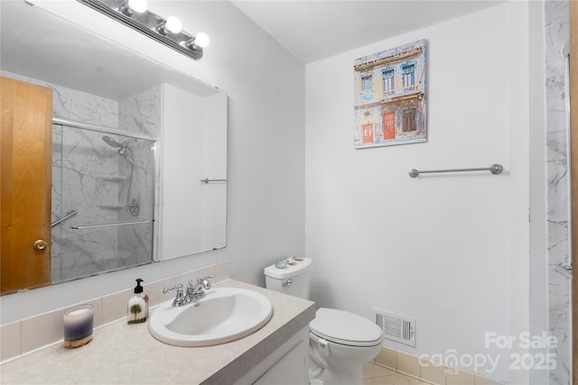 bathroom with visible vents, toilet, vanity, and a marble finish shower