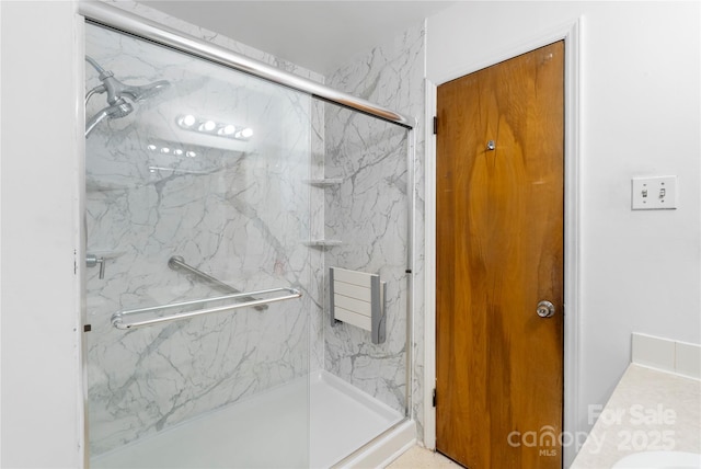 bathroom featuring a marble finish shower