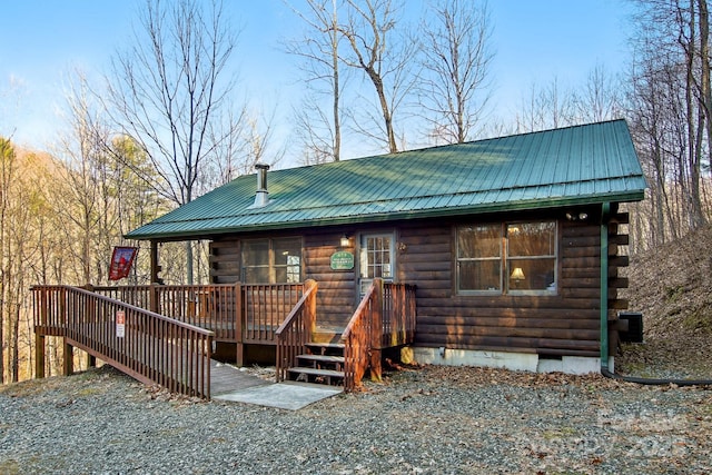 back of property featuring metal roof, crawl space, log siding, and a wooden deck