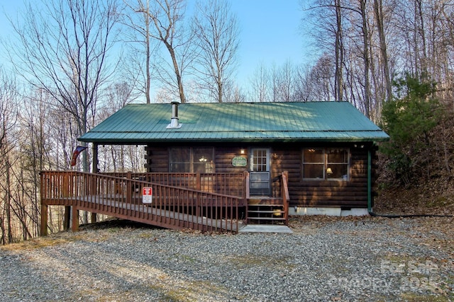 view of front of home with crawl space, metal roof, and a wooden deck