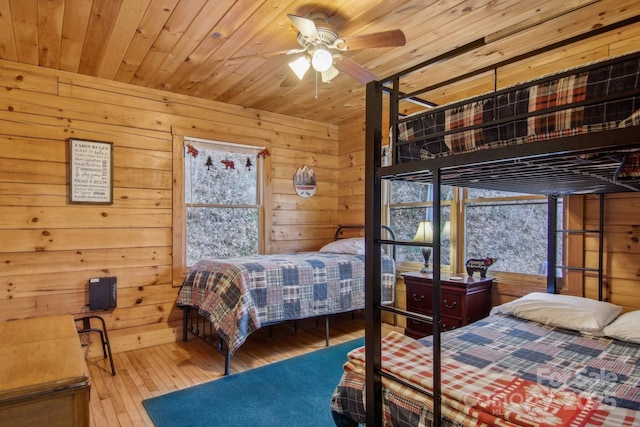 bedroom featuring wooden ceiling, hardwood / wood-style floors, and wood walls