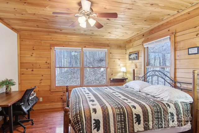 bedroom with wood walls, wood finished floors, wood ceiling, and a ceiling fan