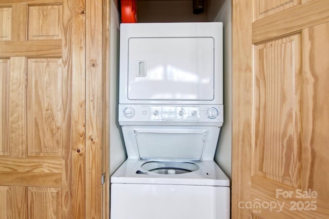 washroom with stacked washer and clothes dryer and laundry area