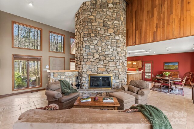 living area with tile patterned flooring, a high ceiling, and a fireplace