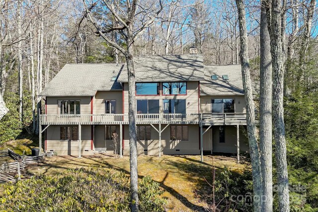 back of house with a shingled roof