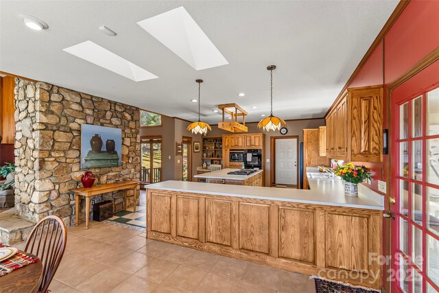 kitchen featuring light countertops, oven, a skylight, and a peninsula