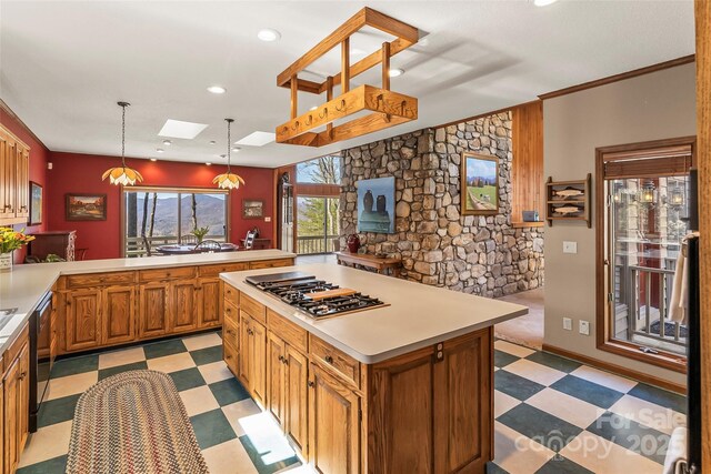 kitchen featuring light countertops, recessed lighting, stainless steel gas stovetop, light floors, and a skylight