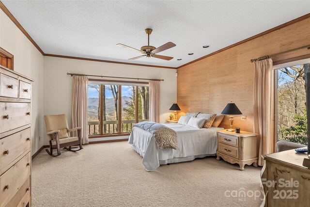 bedroom featuring ornamental molding, a ceiling fan, a textured ceiling, and light colored carpet