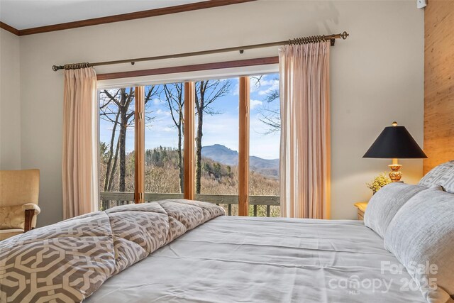 bedroom featuring crown molding, access to outside, and a mountain view