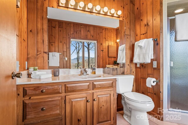 full bath with vanity, wood walls, toilet, and a shower stall