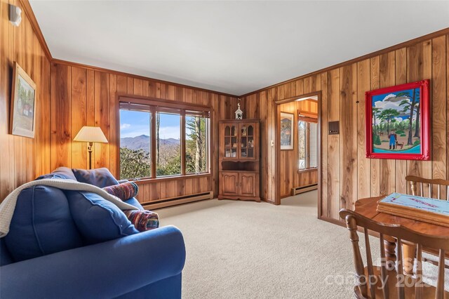 living area featuring carpet floors, wooden walls, a mountain view, and baseboard heating