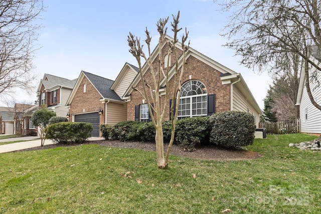 traditional-style house featuring a garage, driveway, brick siding, and a front yard