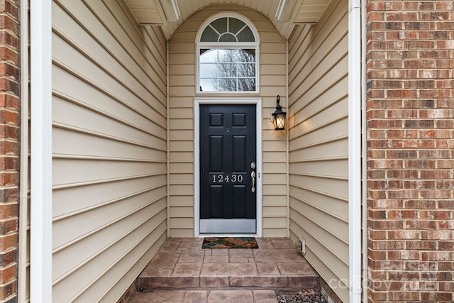 doorway to property featuring brick siding