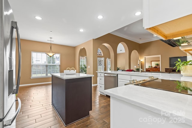 kitchen featuring stainless steel appliances, recessed lighting, wood tiled floor, white cabinets, and a kitchen island