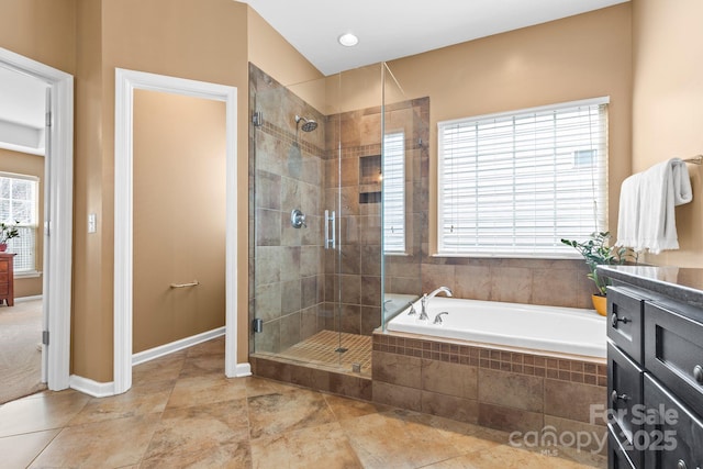 full bath with a stall shower, a garden tub, vanity, and baseboards