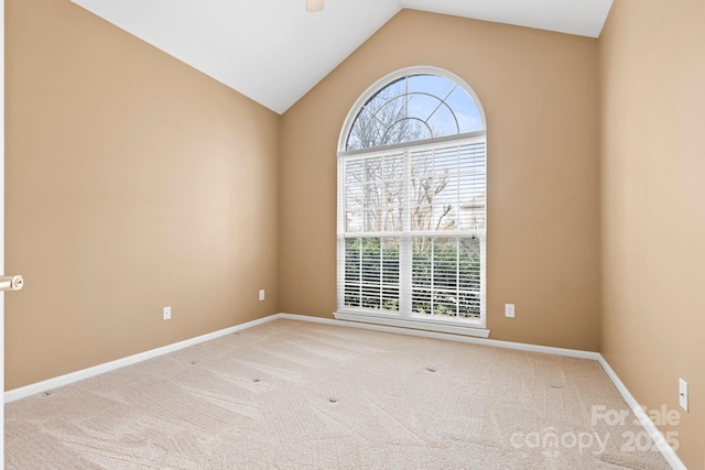 carpeted empty room featuring lofted ceiling, plenty of natural light, and baseboards