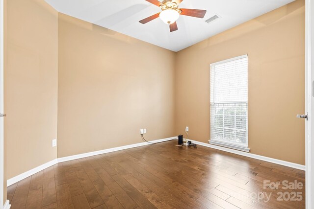 unfurnished room with ceiling fan, hardwood / wood-style floors, visible vents, and baseboards