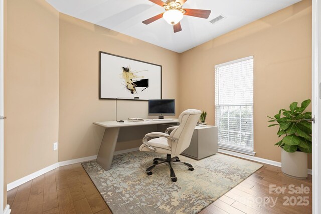 office featuring ceiling fan, wood-type flooring, visible vents, and baseboards