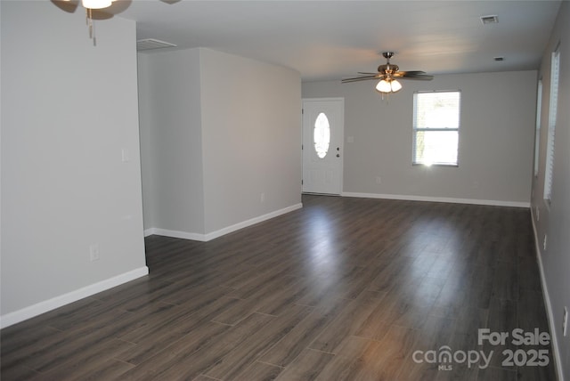 unfurnished living room featuring ceiling fan, dark wood-style flooring, visible vents, and baseboards