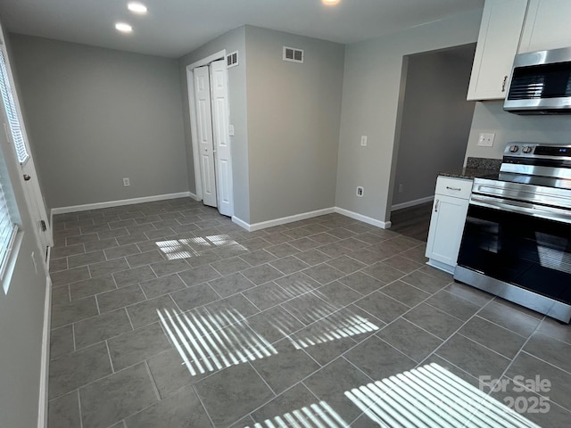 kitchen featuring visible vents, appliances with stainless steel finishes, white cabinets, and baseboards