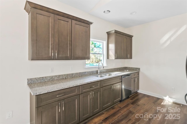 kitchen with dark brown cabinetry, a sink, dark wood-style floors, baseboards, and dishwasher