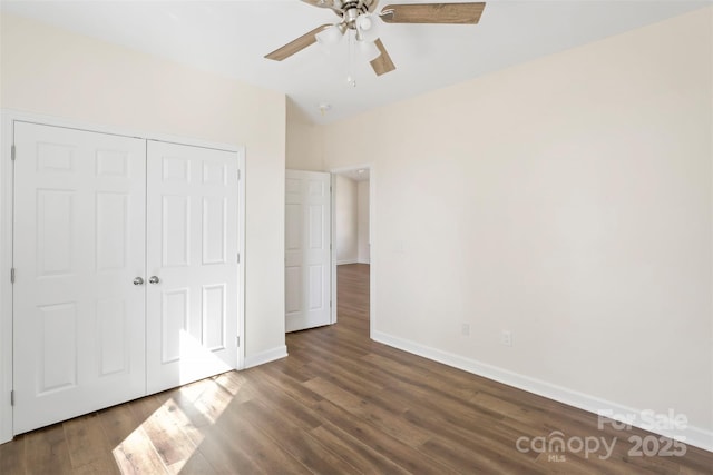 unfurnished bedroom featuring ceiling fan, a closet, wood finished floors, and baseboards