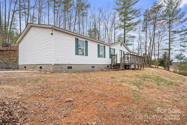 view of property exterior with crawl space and a wooden deck