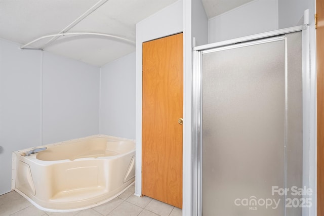 bathroom featuring a garden tub, a shower stall, and tile patterned floors