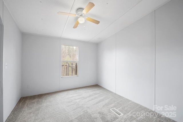 empty room with carpet, visible vents, and ceiling fan