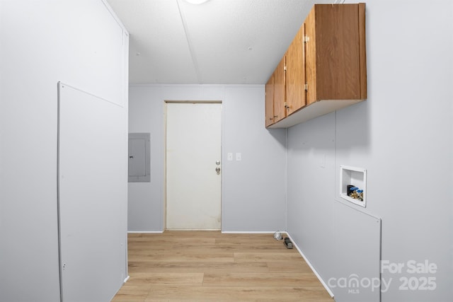 washroom featuring a textured ceiling, washer hookup, light wood-type flooring, cabinet space, and electric panel