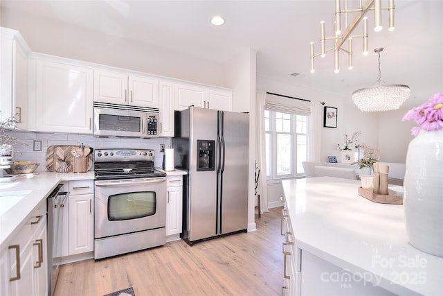 kitchen with stainless steel appliances, tasteful backsplash, and white cabinetry