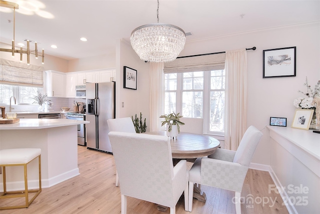 dining area with baseboards, light wood finished floors, and a healthy amount of sunlight