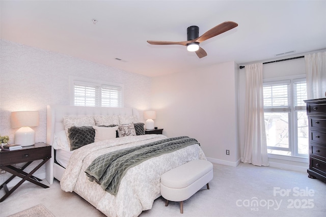 carpeted bedroom with a ceiling fan, visible vents, and baseboards